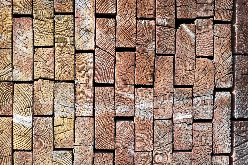 Gestapelde balken hout van de kopse kant gezien, met de jaarringen zichtbaar